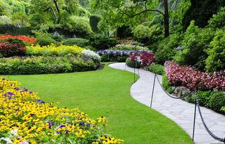 Gepflegte Grünanlage mit Blumenbeeten und Weg